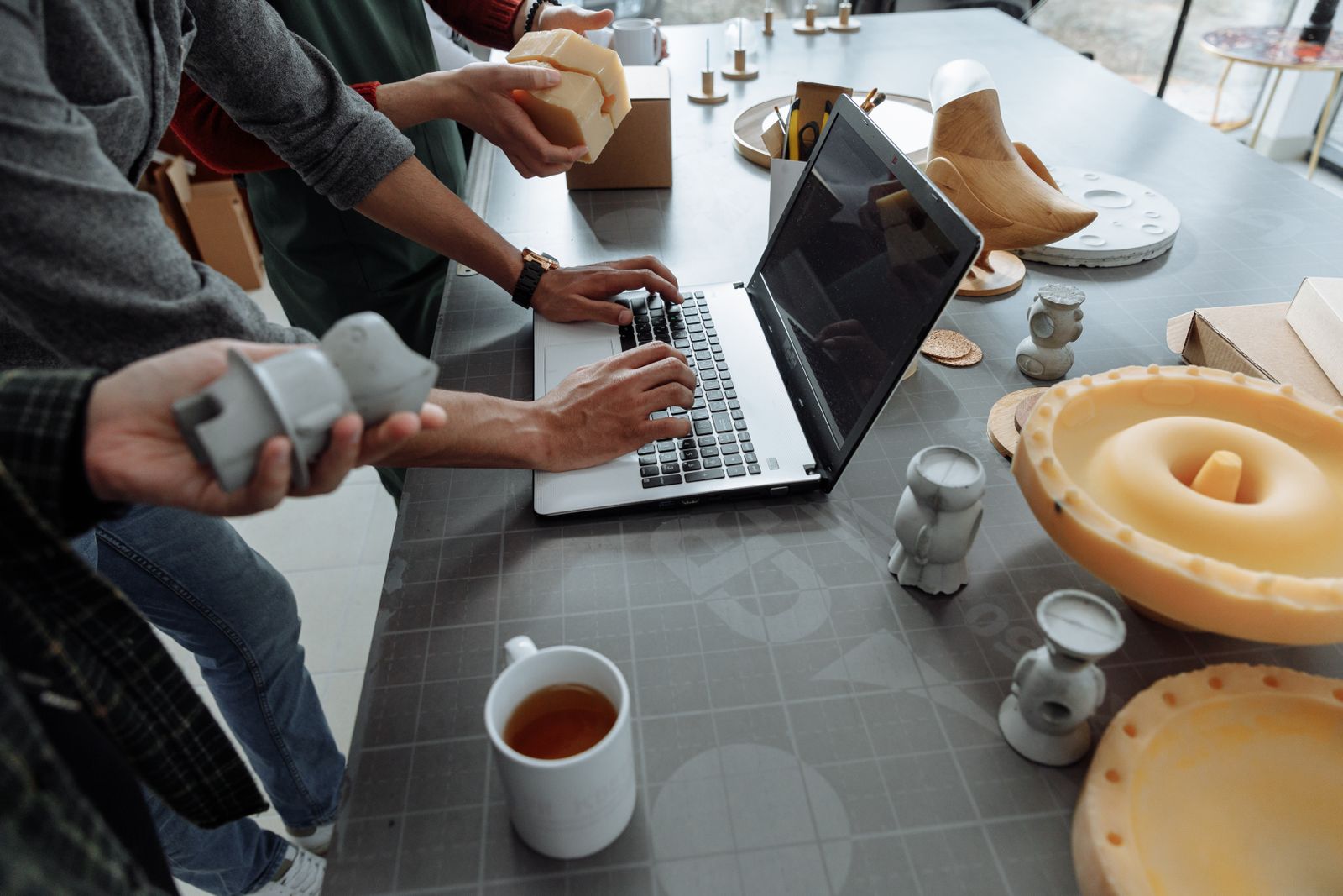 Diseñadores examinando prototipos y materiales de un producto en un taller de diseño, aplicando criterios de ecodiseño