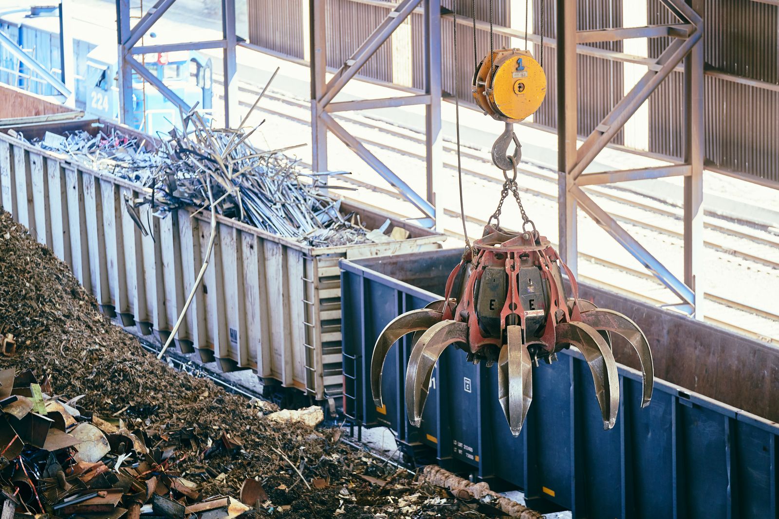 Grúa industrial recogiendo chatarra metálica en una planta de reciclaje para recuperar materiales e incorporarlos a nuevos ciclos productivos