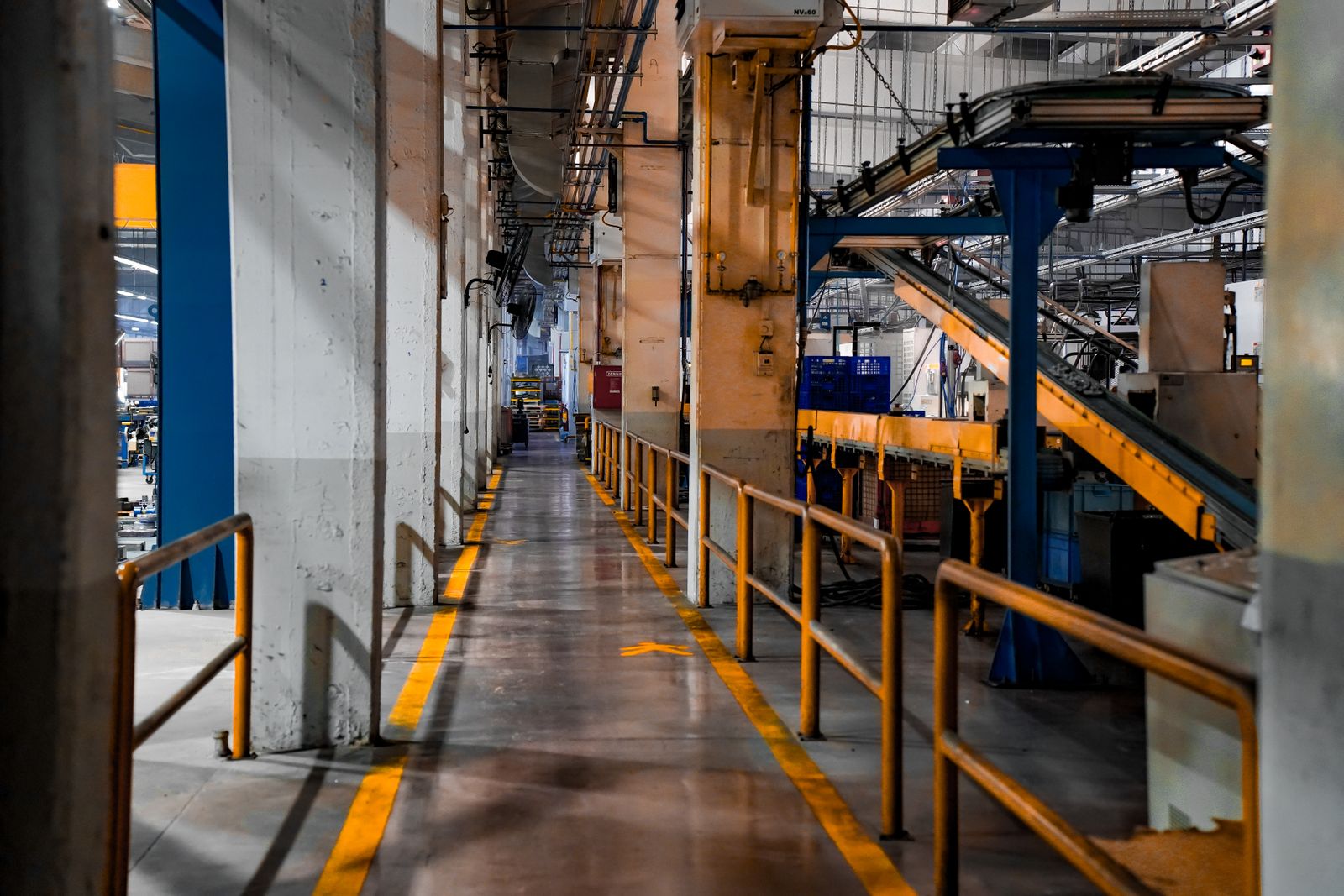 Interior de una fábrica moderna con cintas transportadoras y maquinaria industrial que representa las distintas etapas del proceso productivo