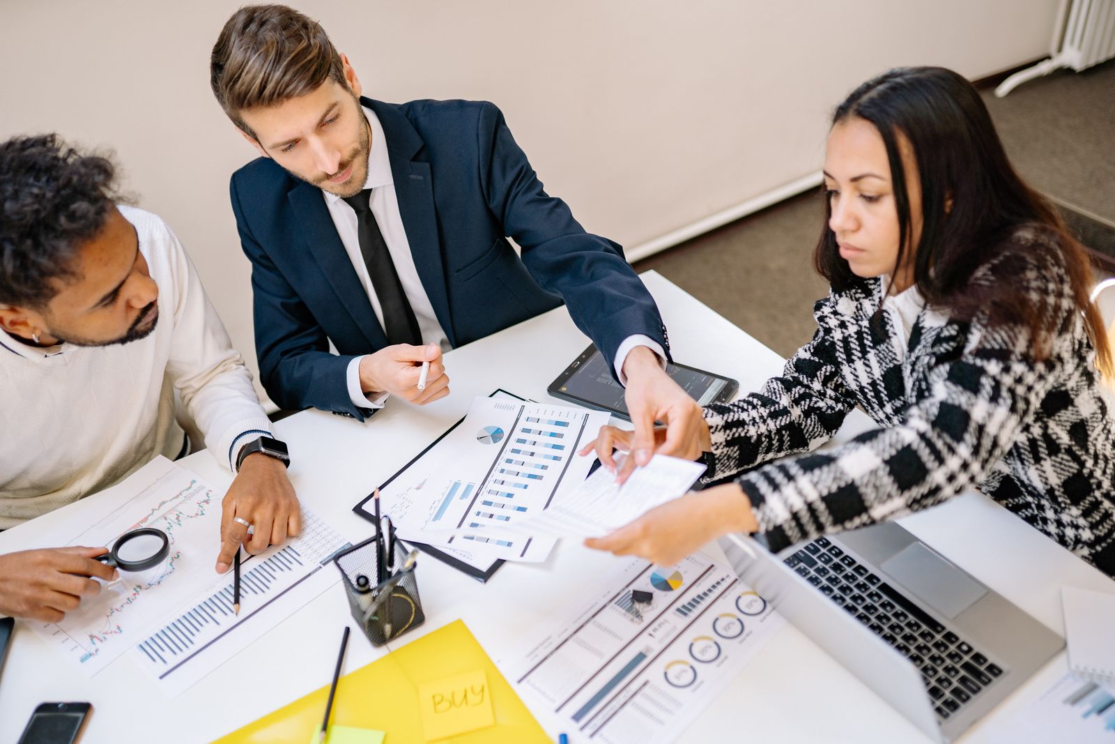 Equipo profesional analizando documentos y datos en una reunión de trabajo